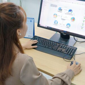 Young woman using desktop computer in office setting in Hanoi, Vietnam.